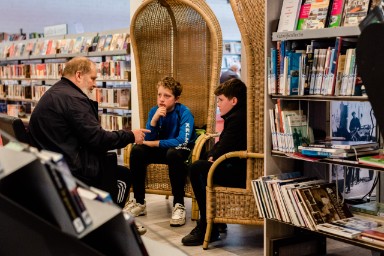 foto met 2 jongens die luisteren naar een levend boek in de bibliotheek